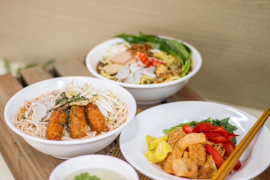 A spread of three main vegetarian Asian noodle dishes from 3 Treasures Vegetarian