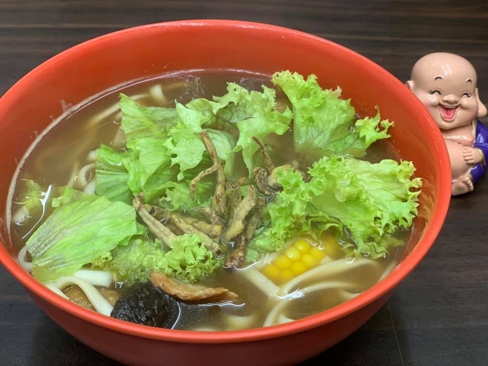 Close-up of a red bowl containing a vegetarian noodle soup from Tian Yuan Healthy Vegetarian Food Paradise