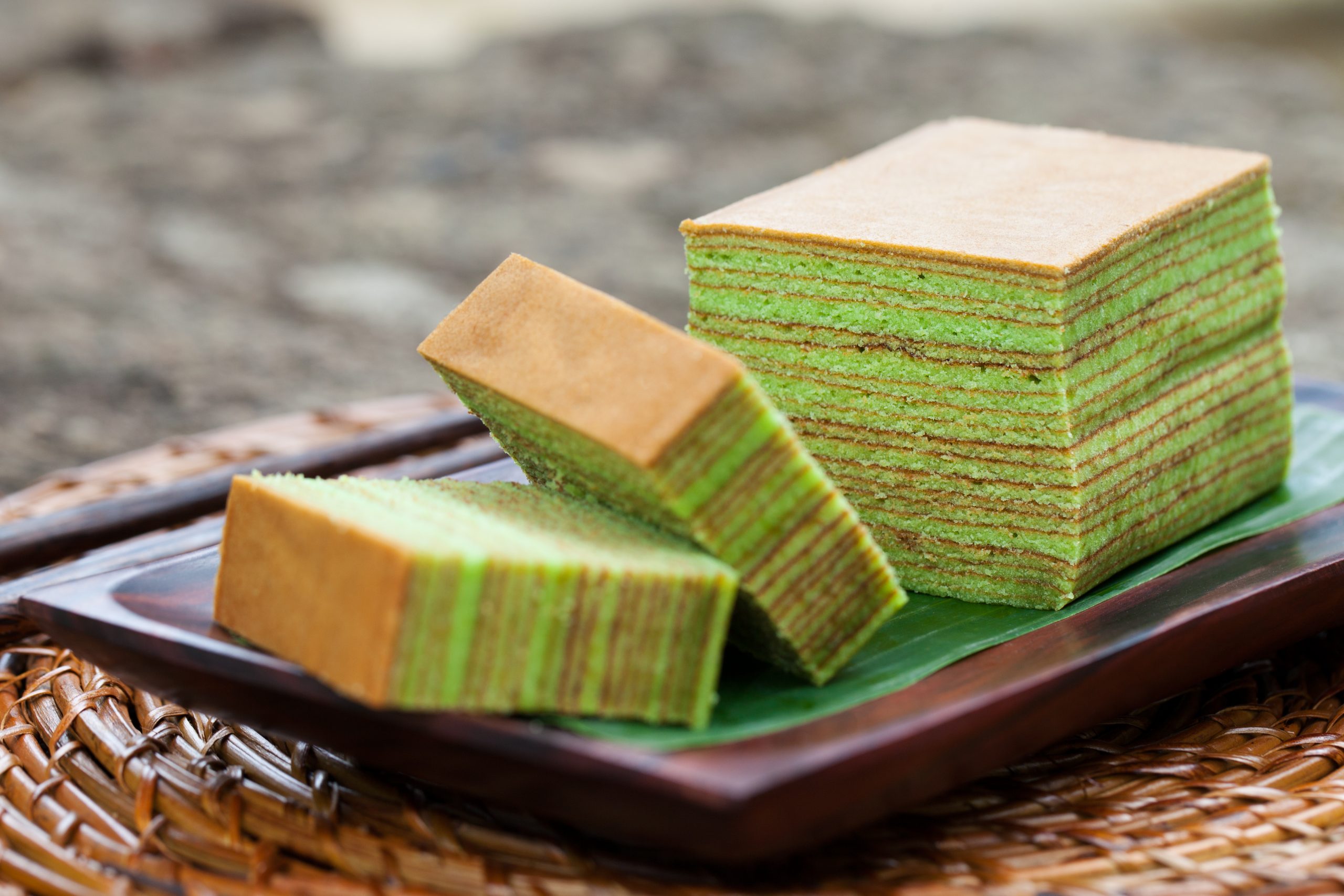 A block and two slices of pandan Kueh Lapis
