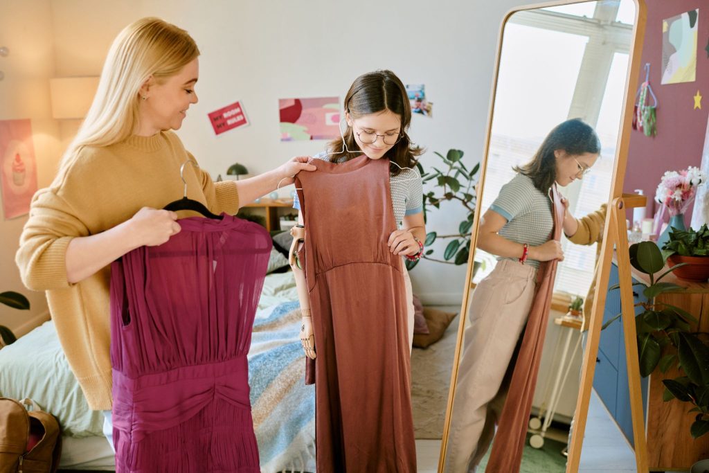 a woman helping out another woman picking out an outfit