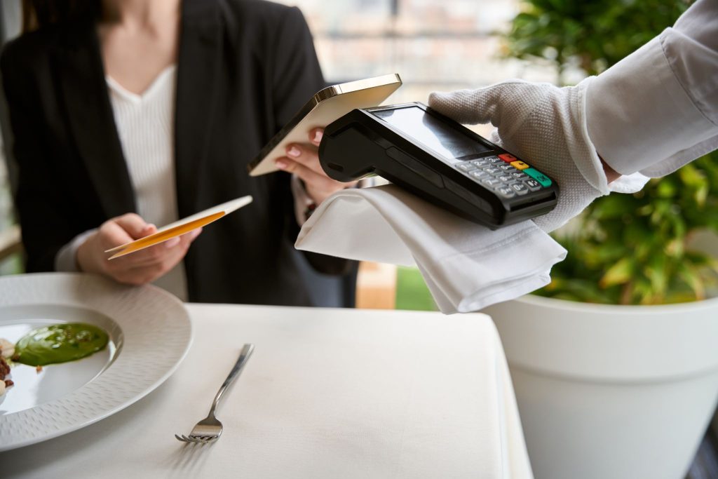 a woman scanning her card on the pos terminal 
